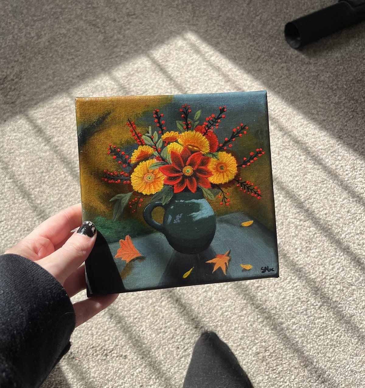 Autumn Bloom held in one hand in the sunlight, showing the size of the canvas