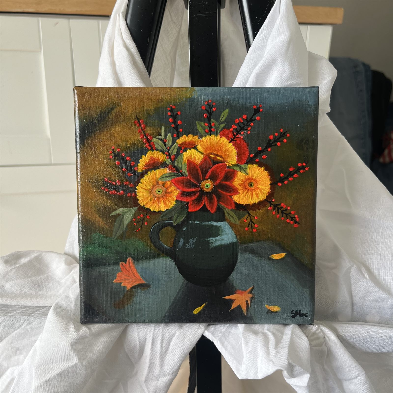 The Autumn Bloom canvas standing on an easel draped with white cloth