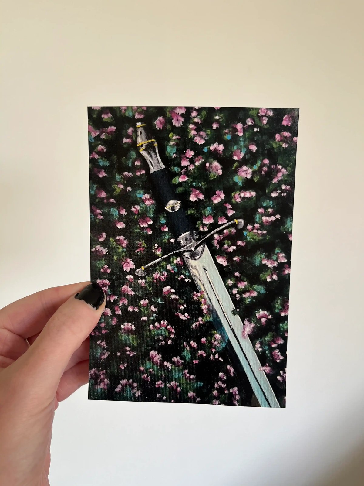 The 6 by 4 inch Lost Sword print held between finger and thumb, showing how small it is