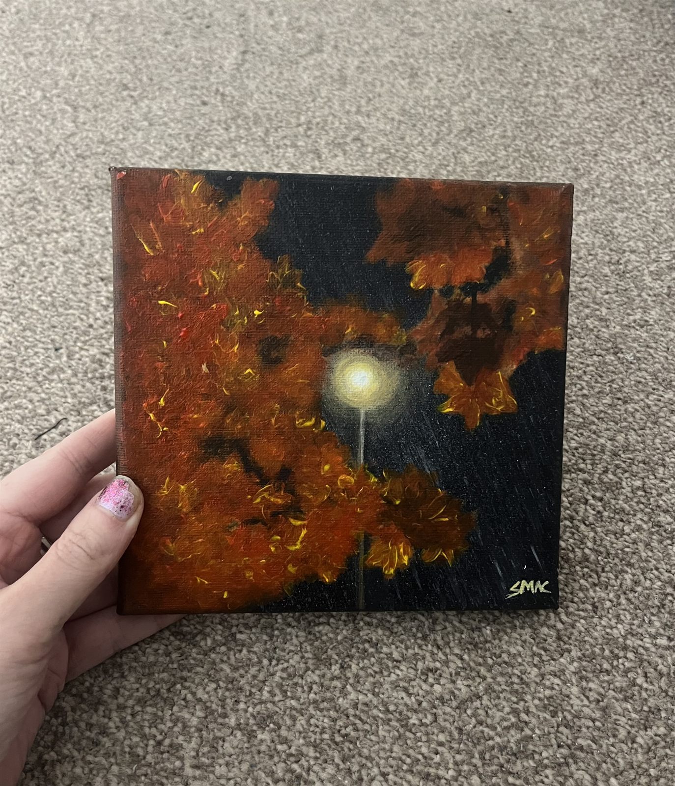 The Walking Home canvas held in one hand, showing how small the six inch square canvas is
